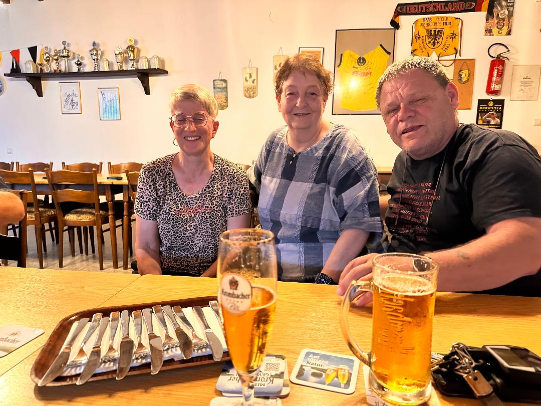 Drei Menschen in geselliger Runde an einem Tisch